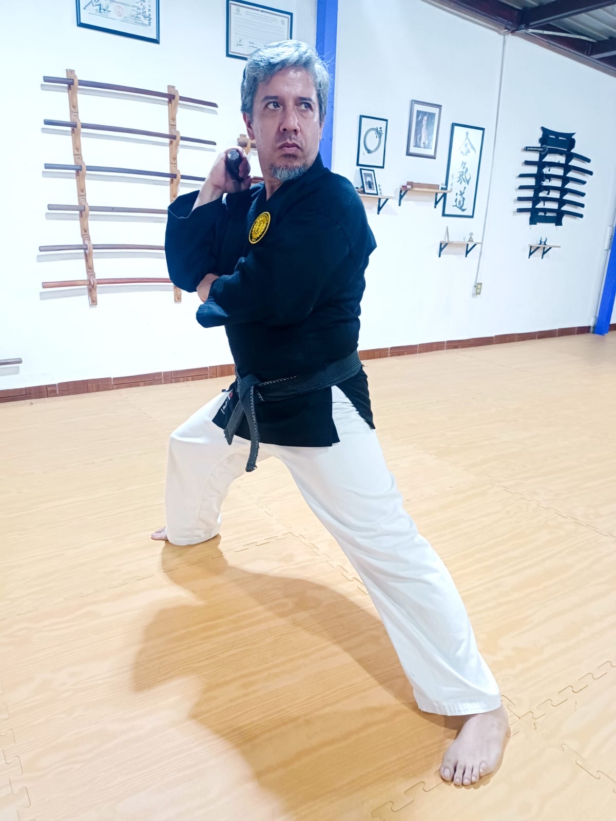 Alejandro Zamorano García en postura de Kobudo dentro del dojo